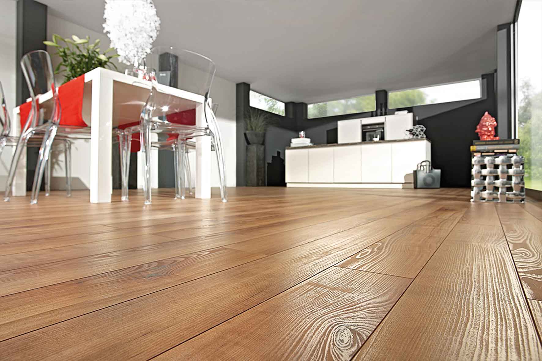 Küche und Esszimmer mit braunem Laminatboden; die Küche verfügt über weiße Schränke und einen weißen Küchenblock, umgeben von schwarzen Wänden. Der angrenzende Essbereich hat weiße Wände, einen weißen Tisch und sechs transparente Acrylstühle.